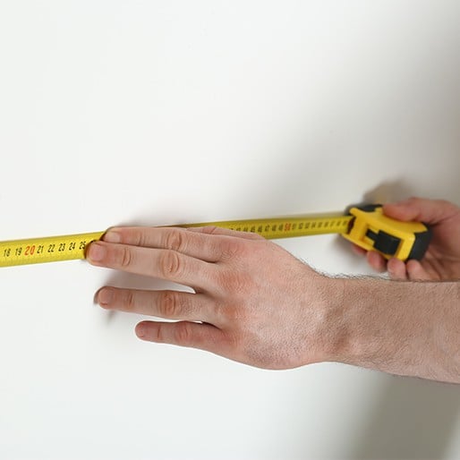 Measure & quote - Man measuring wall with tape measure