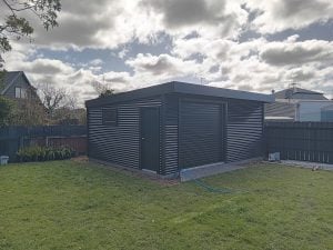 Black Garage shed with Roller door on concrete pad in Tauranga