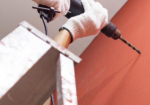 Secure & fasten Person drilling into wall